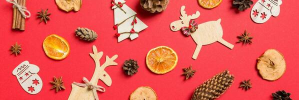 Top view Banner of red background decorated with festive toys and Christmas symbols reindeers and New Year trees. Holiday concept photo