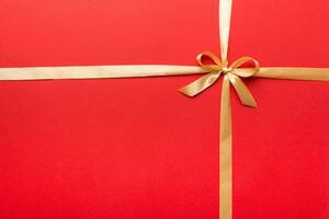 Top view of gold ribbon rolled and yellowbow isolated on colored background. Flat lay with copy space photo