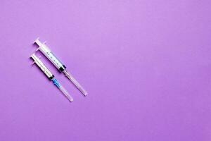 Top view of different syringes for injection on colorful background. Medical equipment concept with copy space photo