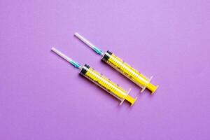Top view of medical syringes on colorful background with copy space. Injection equipment concept photo