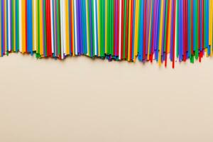 Heap of colorful plastic drinking straws on Colored background, flat lay. Copy Space for text photo