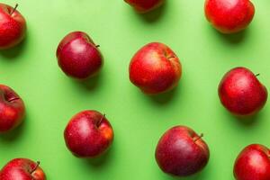 Many red apples on colored background, top view. Autumn pattern with fresh apple above view photo