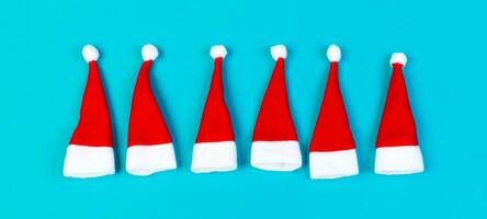 Top view of red Santa hats on colorful background. Merry Christmas Banner concept with copy space photo