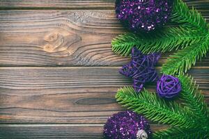 Christmas composition made of fir tree, balls and different decorations on wooden background. Top view of New Year Advent concept with empty space for your design photo