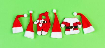 Top view of red Santa hats and clothes on colorful background. Banner Merry Christmas concept with copy space photo