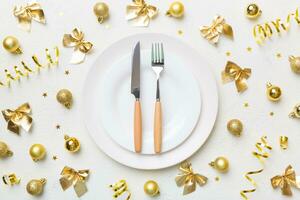 Christmas table place setting with christmas decor and plates, kine, fork and spoon. Christmas holiday background. Top view photo