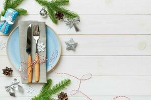 Christmas table place setting with christmas decor and plates, kine, fork and spoon. Christmas holiday background. Top view with copy space photo