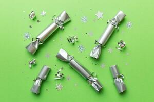 Christmas crackers with shiny confetti on color background, top view, copy space photo