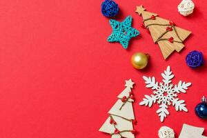 Top view of holiday decorations and toys on red background. Christmas ornament concept with empty space for your design photo