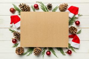 Flat lay Christmas composition. square Paper blank, pine tree branches, christmas decorations on Colored background. Top view, copy space for text photo