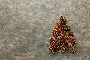 Christmas tree made from natural cones on colored background, view from above. New Year minimal concept with copy space photo