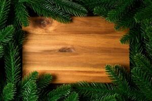 Top view of wooden plate decorated with fir tree branches. New Year dinner concept with empty space for your design photo