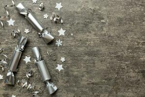 Christmas crackers with shiny confetti on color background, top view, copy space photo