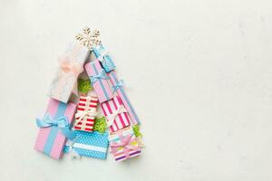 Christmas tree made of beautifuly wrapped presents on colored background, view from above. New Year gift box minimal concept with copy space photo