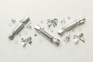 Christmas crackers with shiny confetti on color background, top view, copy space photo