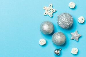 Creative set of New Year baubles and decorations on colorful background. Top view of Christmas time concept. Copy space photo