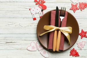 vista superior del plato, tenedor y cuchillo servido sobre fondo de madera decorado con navidad. concepto de víspera de año nuevo con espacio de copia foto