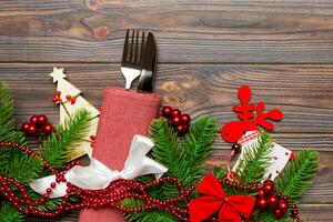 Top view of flatware tied up with ribbon on napkin on wooden background. Christmas decorations and reindeer with empty space for your design. New Year holiday concept photo