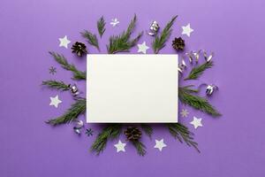 Flat lay Christmas composition. square Paper blank, pine tree branches, christmas decorations on Colored background. Top view, copy space for text photo