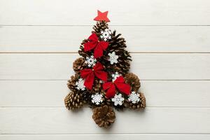 Christmas tree made from natural cones on colored background, view from above. New Year minimal concept with copy space photo