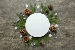 Flat lay Christmas composition. Round Paper blank, pine tree branches, christmas decorations on Colored background. Top view, copy space for text photo