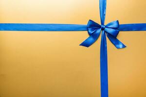 Top view of blue ribbon rolled and blue bow isolated on colored background. Flat lay with copy space photo