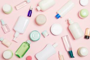 Group of plastic bodycare bottle Flat lay composition with cosmetic products on pink background empty space for you design. Set of White Cosmetic containers, top view with copy space photo