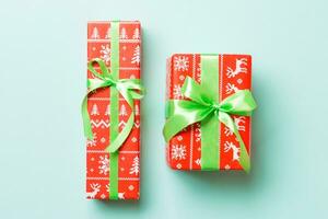 Top view Christmas present box with green bow on blue background photo