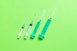 Top view of different syringes for injection on colorful background. Medical equipment concept with copy space photo