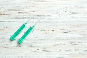 Top view of syringes on wooden background with copy space. Medical equipment for injection concept photo