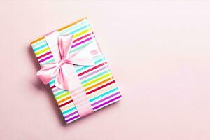 regalo caja con rosado arco para Navidad o nuevo año día en rosado fondo, parte superior ver con Copiar espacio foto