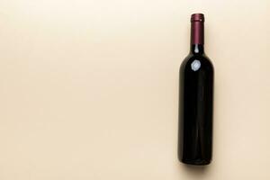 One Bottle of red wine on colored table. Flat lay, top view wth copy space photo