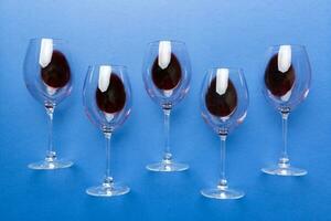 Many glasses of red wine at wine tasting. Concept of red wine on colored background. Top view, flat lay design photo