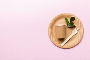 set of empty reusable disposable eco-friendly plates, cups, utensils on light white colored table background. top view. Biodegradable craft dishes. Recycling concept. Close-up photo