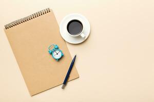Modern office desk table with notebook and other supplies with cup of coffee. Blank notebook page for you design. Top view, flat lay photo