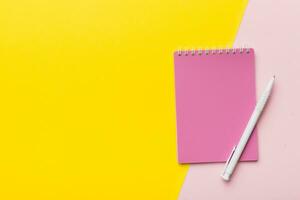 two school colored notebook on a desk background, spiral craft notepad on a table Top view photo