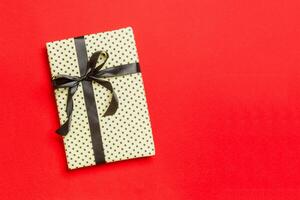 regalo caja con negro arco para Navidad o nuevo año día en rojo fondo, parte superior ver con Copiar espacio foto