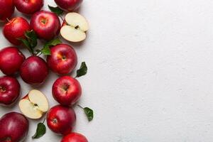 Fresh red apples with green leaves on wooden table. On wooden background. Top view free space for text photo
