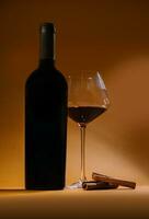 Bottle with red wine and glass and cinnamon photo