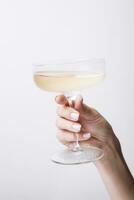 Hand holds glass goblet with champagne photo