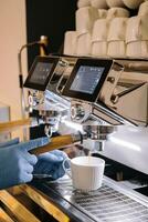 Professional coffee machine with white cup and pouring drink photo