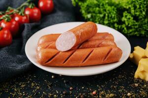 boiled sausages with cheese on plate photo