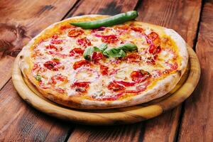 Pizza with basil, red onion and sausage on a wooden board photo