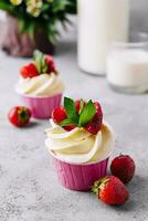 Vanilla cupcake with white cream and strawberries photo