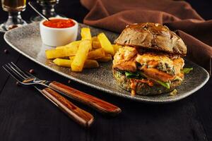 Burger with salmon, lettuce and fried potato photo