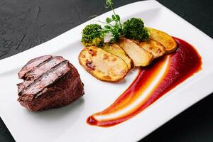 Appetizing fried beef steak with potatoes on plate photo