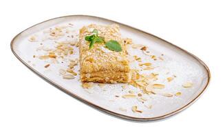 Napoleon Cake with almond on a white plate photo