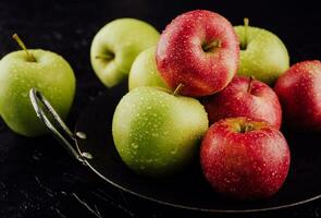 Closeup of apples with water drops on plate photo