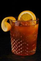 Old-fashioned cocktail with ice and orange peel photo