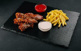 Hot and spicy buffalo chicken wings and french fries photo